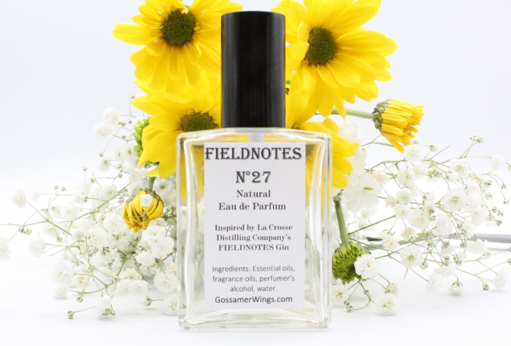 Bottle of Fieldnotes Eau de Parfum with daisies and white flowers